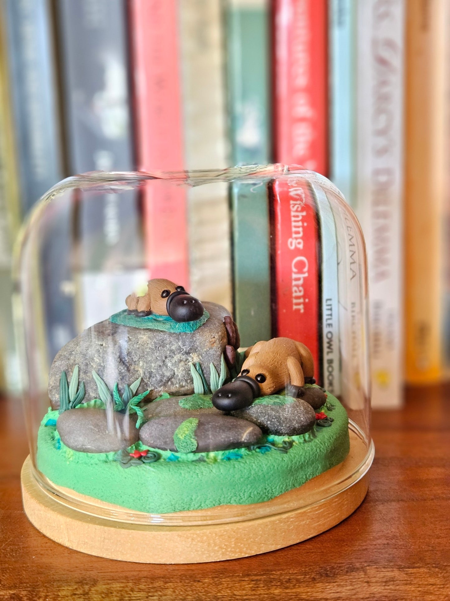 Platypus on rocks sculpture in glass cloche