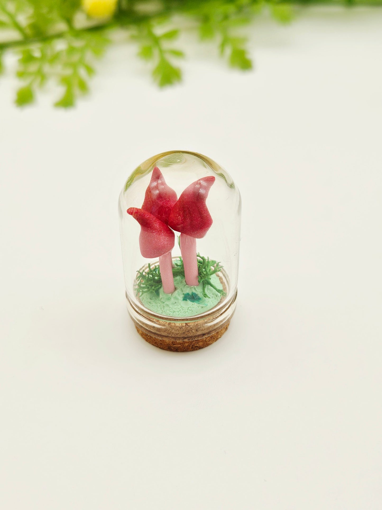 Mini pink mushroom trio under glass