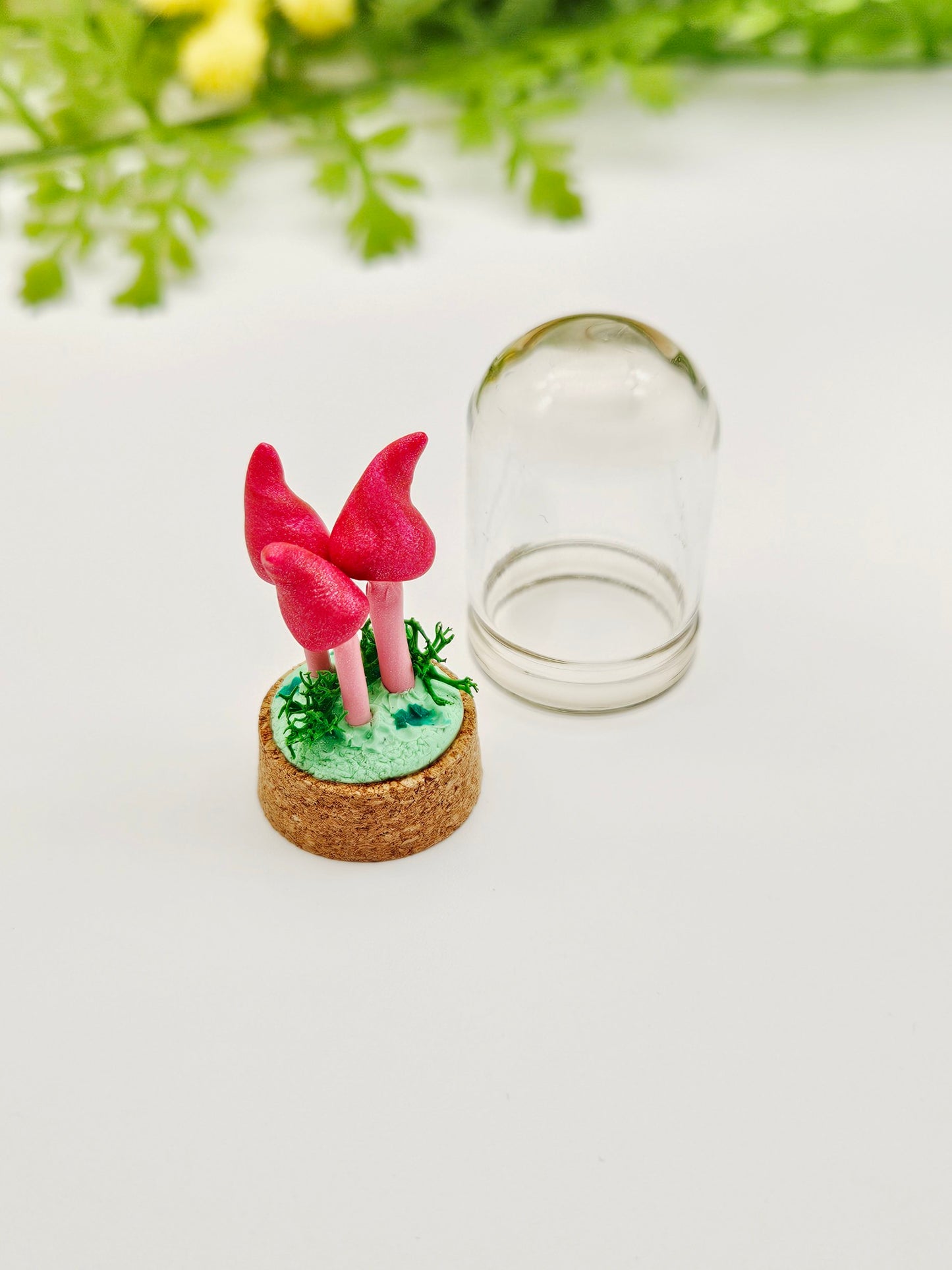 Mini pink mushroom trio under glass