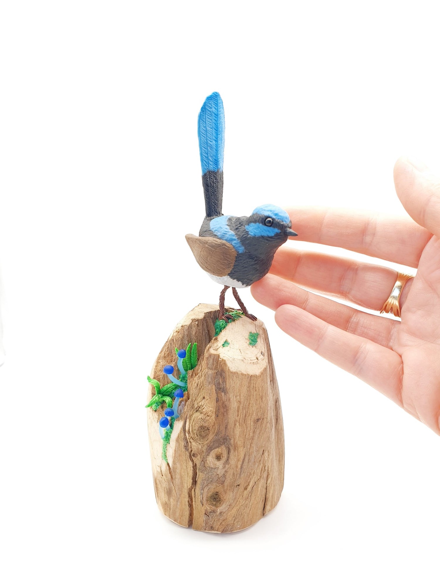 Blue fairy wren sculpture on a piece of driftwood with tiny blue mushrooms & ferns. hand sculpted from polymer clay