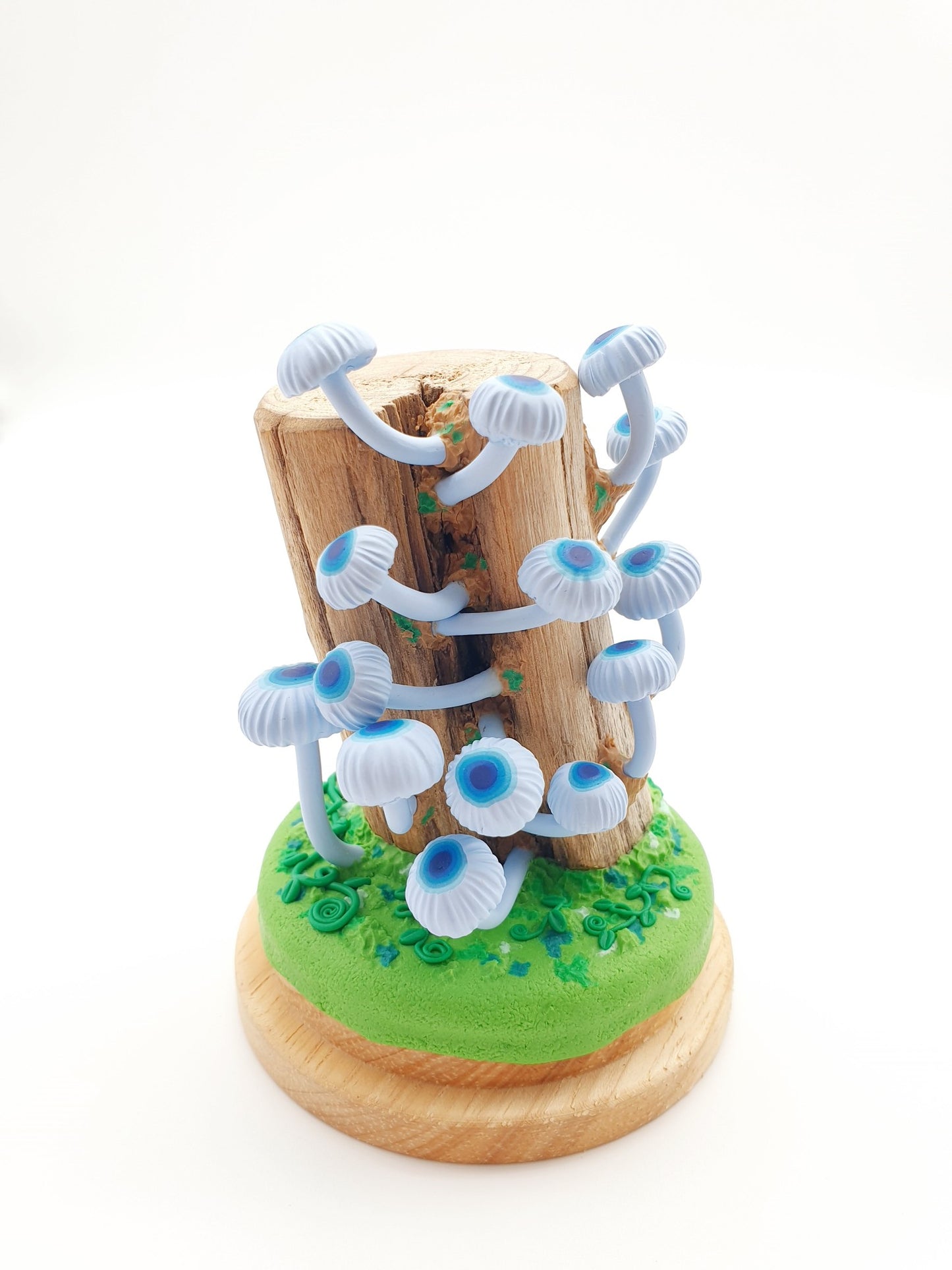 Blue mushrooms Mycena Interrupta on wood sculpture