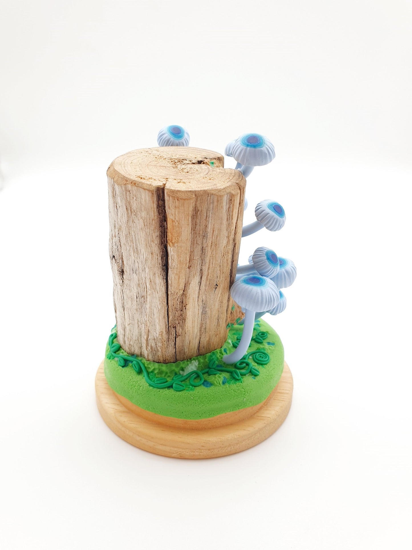Blue mushrooms Mycena Interrupta on wood sculpture